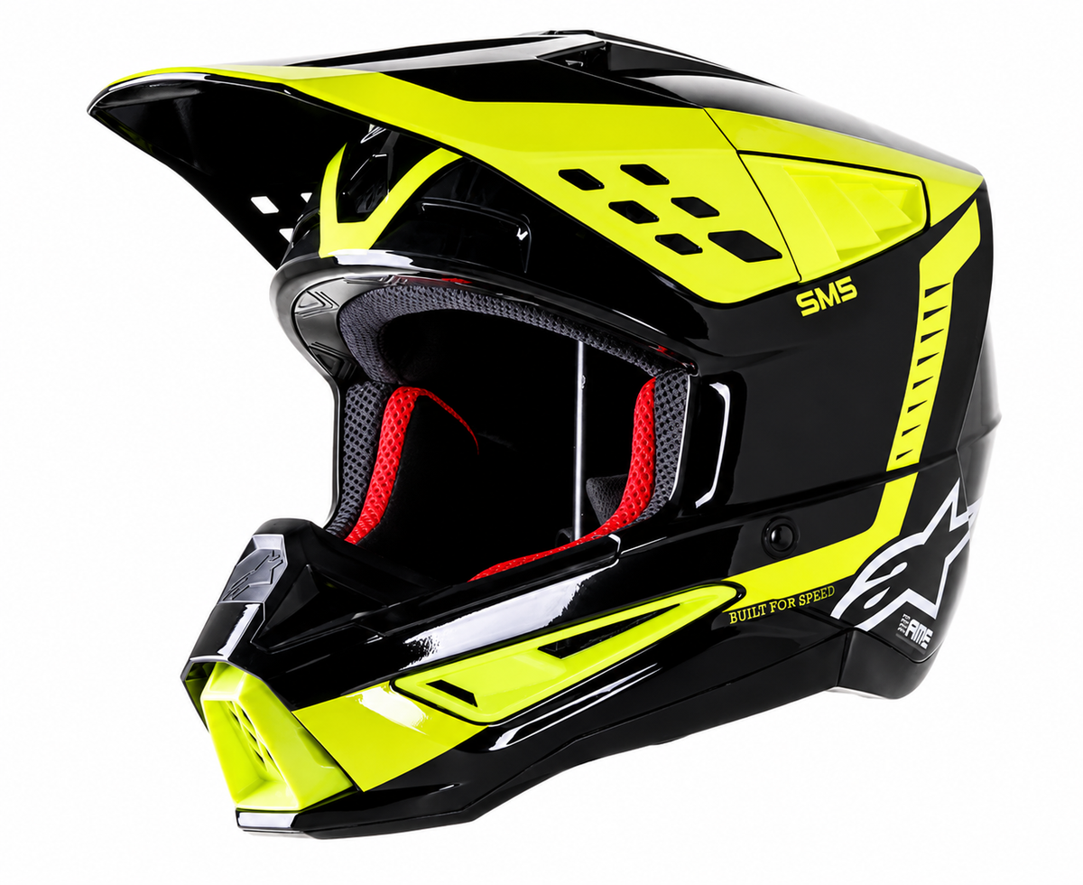 A high-performance motocross helmet in glossy black and neon yellow, featuring a full visor, red interior padding, and white Alpinestars branding on a clean white background.
